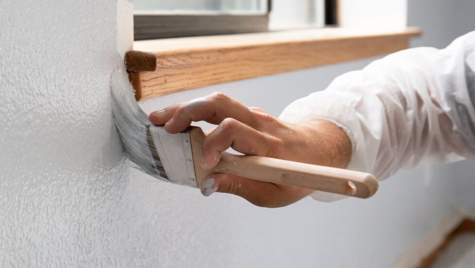 Painting applying paint to trim interior window